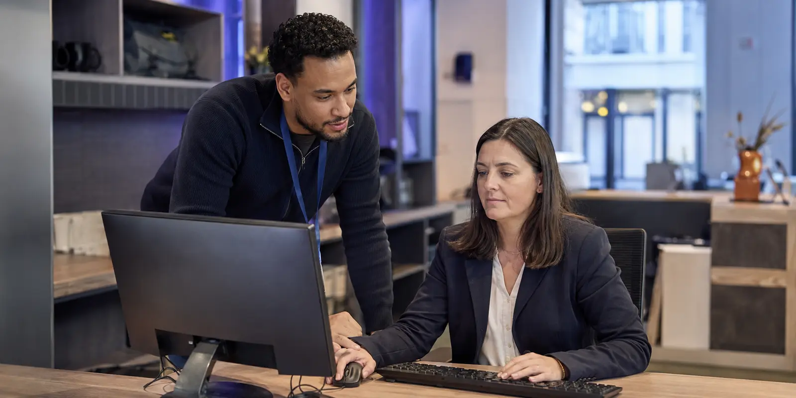 Technicien IT accompagnant une utilisatrice sur son poste de travail